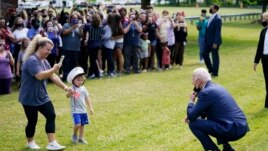 President Joe Biden stops outside at York High School and is greeted by a child and his mother, Monday, May 3, 2021, in Yorktown, Va.
