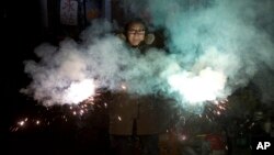 A resident lets off sparklers on the eve of Lunar New Year in Beijing, China, Jan. 27, 2017. Chinese worldwide celebrate the Year of the Rooster, Jan 28, 2017, with family reunions and fireworks.