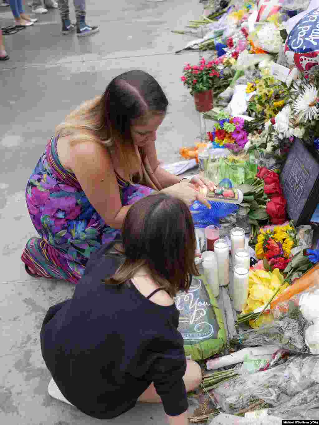 A young woman and girl visit the memorial site in Dallas for the five police officers killed by a sniper Thursday night, July 9, 2016.