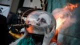 Activists from climate action group Ocean Rebellion take part in a performance using liquid natural gas beside the International Memorial to Seafarers on the Albert Embankment in London on Oct. 4, 2024. 