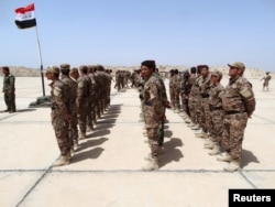 FILE - Sunni tribesmen attend a ceremony to present them with weapons at Camp Habbaniyah, in the eastern city of Ramadi, April 8, 2015.