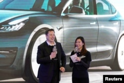 特斯拉執行總裁馬斯克和特斯拉中國區高管陶琳在上海舉行的國產特斯拉Model 3型汽車交付儀式上。（2021年1月7日）