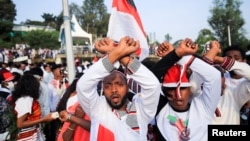 FILE: People show the Oromo Protest gesture as they chant anti-government slogans during Irreechaa Festival, the Oromo People thanksgiving ceremony at the Hora Finfinnee, in Addis Ababa, Ethiopia,. Taken Oct. 2, 2021. 