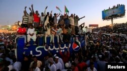 Warga berunjuk rasa menyuarakan protes terhadap pemerintah yang berkuasa di negara itu, di luar kantor Menteri Pertahanan Sudan di Khartoum, Sudan, 21 April 2019.