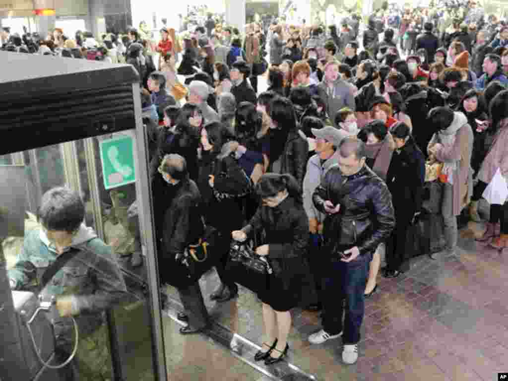 People line up in front of public telephone booths at Shibuya station in Tokyo March 11, 2011. The biggest earthquake to hit Japan since records began 140 years ago struck the northeast coast on Friday, triggering a 10-metre tsunami that swept away everyt