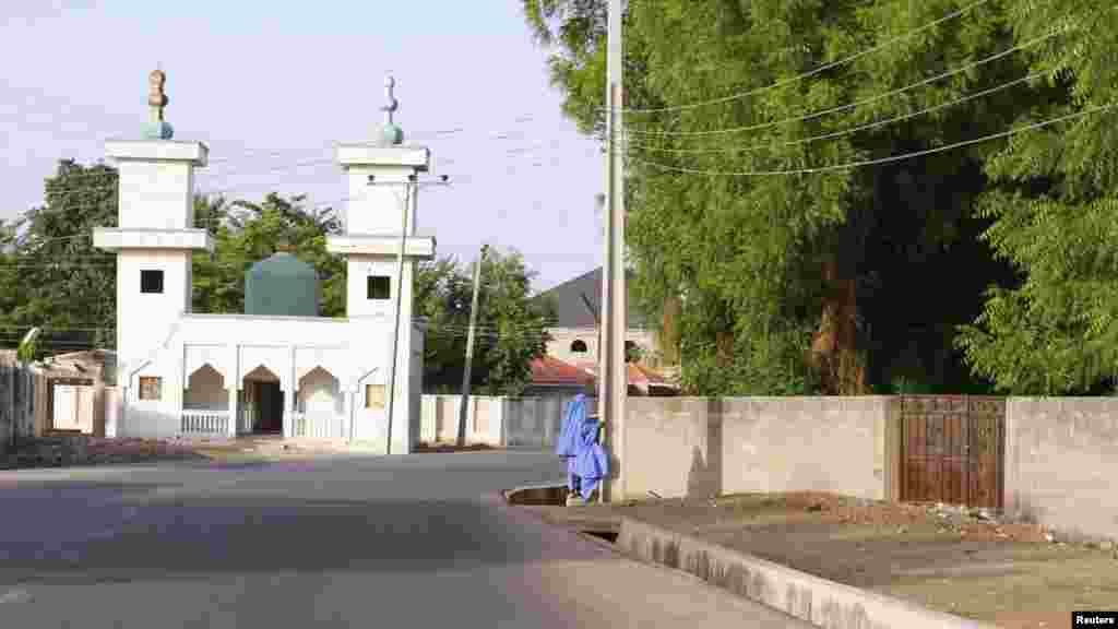 Two children walk in an empty street as they make their way home in the city of Maiduguri, Borno State May 19, 2013.