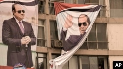 A man peers out of a window under a giant banner supporting Egyptian President Abdel Fattah el-Sissi during a march in Cairo, Egypt, Oct. 2, 2023. Egypt will hold a presidential election over three days in December, with el-Sissi likely to prolong his stay in power until 2030. 