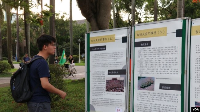 台湾大学校园内，学生驻足阅读海报上的六四历史。（美国之音李玟仪拍摄）