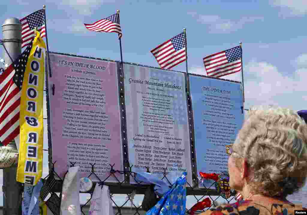 A woman looks at a memorial of mementos dedicated to the 19 firefighters killed in the nearby wildfire, in Prescott, Arizona, July 8, 2013. 