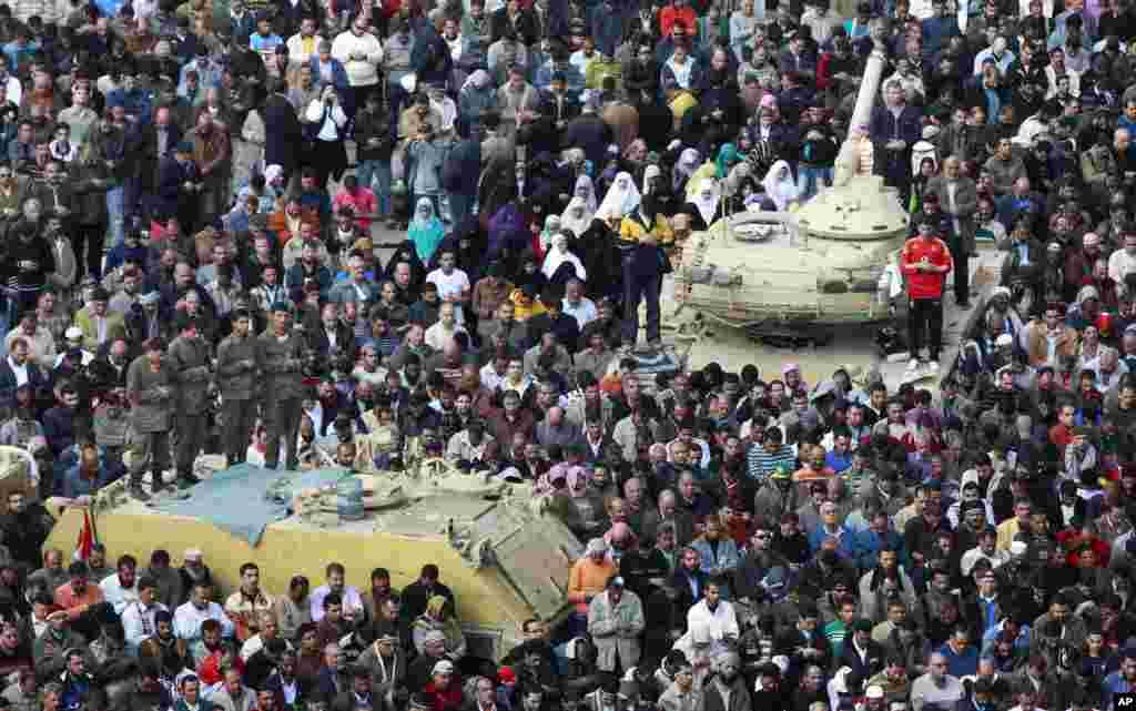 Anti-government protesters and Egyptian Army soldiers on their vehicles make traditional Muslim Friday prayers in Tahrir Square, Feb. 11, 2011.