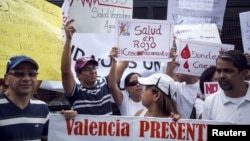 Protesters in front of a social security office hold placards demanding medicine in Caracas, Venezuela, Aug. 27, 2015.