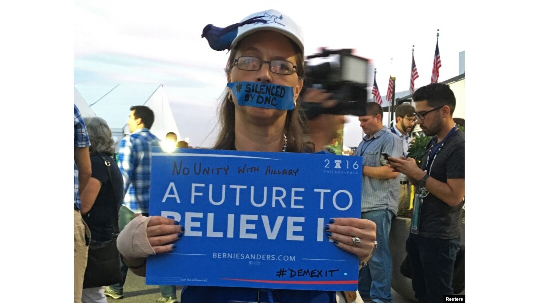 FILE - A Bernie Sanders supporter hold up a signs during an improvised protest in front of the media tents on Day 2 of the Democratic National Convention at the Wells Fargo Center in Philadelphia, Pennsylvania, July 26, 2016.
