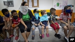 Los niños ven una obra de teatro en un centro que brinda tutoría a niños en medio de la nueva pandemia del cornavirus, en Caracas, Venezuela, el jueves 4 de noviembre de 2020.