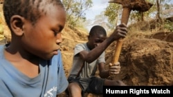 FILE - Two 13-year-old boys dig for gold ore at a small-scale mine in Mbeya Region, Tanzania, in this 2013 photo.