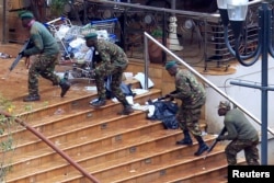 FILE - Kenya Defense Forces soldiers take their position at the Westgate shopping center on the fourth day since al-Shabab militants stormed into the mall in Nairobi, Sept. 24, 2013.