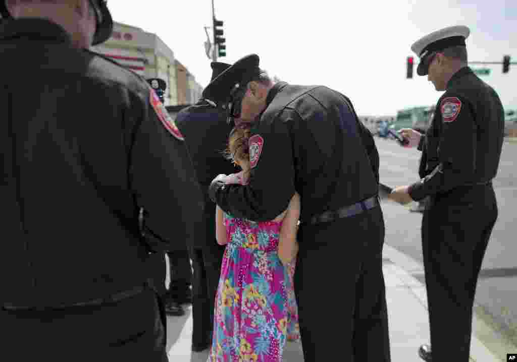 Anaheim, California firefighter Brent Hirst, center, kisses his daughter, Morgan, 9, on the head while waiting to enter Tim&#39;s Toyota Center for a memorial service, &nbsp;July 9, 2013 in Prescott, Arizona.&nbsp;