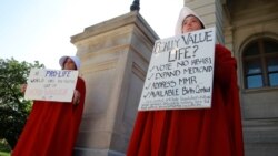 April Houston and Lara Martin hold signs while dressed as Handmaids in protest of Georgia's anti-abortion "heartbeat" bill at the Georgia State Capitol in Atlanta, Georgia, U.S., May 7, 2019.