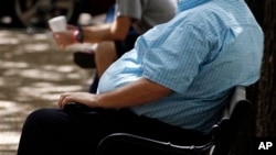 Seorang pria dengan berat badan berlebih duduk di sebuah bangku di Jackson, Mississippi. Semakin banyak orang dewasa Amerika yang termasuk dalam tingkat obesitas yang membahayakan dan perut yang berlemak, walaupun data pemerintah menunjukkan bahwa tingkat obesitas secara keseluruhan tidak bertambah. (Foto: dok.)