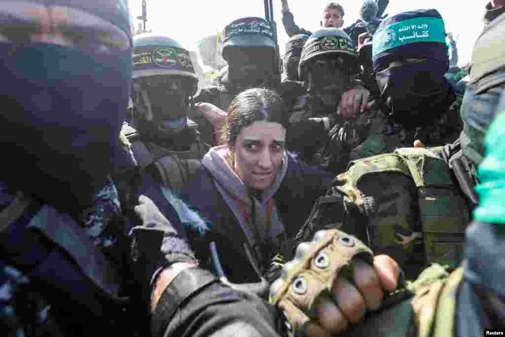 Palestinian militants surround hostage Arbel Yehoud, held in Gaza since the deadly October 7 2023 attack, as they hand her to members of the International Committee of the Red Cross in Khan Younis in the southern Gaza Strip.