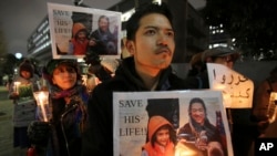 FILE - Protesters holding signs bearing a photo of Japanese journalist Kenji Goto, who was taken hostage by the Islamic State group, appeal to the government to save Goto during a rally in front of the prime minister's official residence in Tokyo.