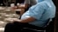 FILE - An overweight man rests on a bench in Jackson, Miss.