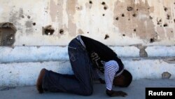 FILE - Somali athlete Abdullah Bare Kuulow prays after a training session in preparation for the 2012 London Olympic Games inside Mogadishu Stadium, March 16, 2012. AFRICOM troops have relocated from the complex, returning its main focus to athletics.