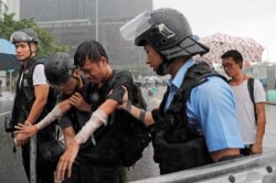 A protester who was pepper sprayed is detained during the anniversary of Hong Kong's handover to China in Hong Kong, July 1, 2019.