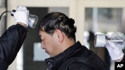 Shyudou Kaneyama is tested for possible nuclear radiation at an evacuation center in Fukushima, north of Japan. Kaneyama was evacuated from his home in Namie, located about 16 km from the crippled nuclear plant. March 28, 2011