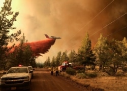 This photo provided by the Oregon Department of Forestry shows a firefighting tanker making a retardant drop over the Grandview Fire near Sisters, Ore., Sunday, July 11, 2021. The wildfire doubled in size to 6.2 square miles (16 square kilometers)…