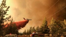 This photo provided by the Oregon Department of Forestry shows a firefighting tanker dropping fire-fighting materials over the Grandview Fire near Sisters, Oregon, July 11, 2021. (AP Photo)