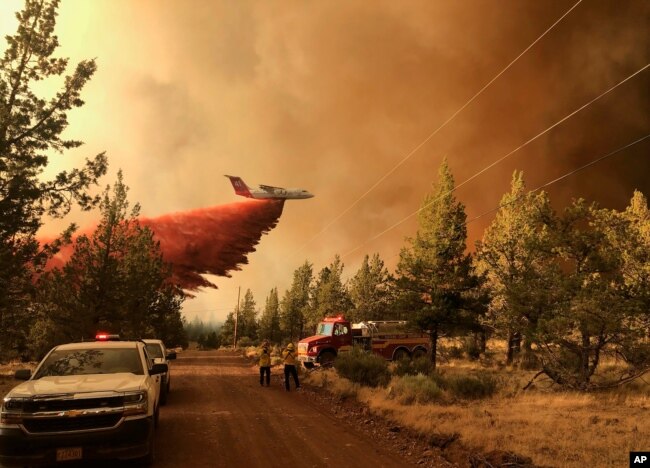 This photo provided by the Oregon Department of Forestry shows a firefighting tanker ｄropping fire-fighting materials over the Grandview Fire near Sisters, Oregon, July 11, 2021. (AP Photo)