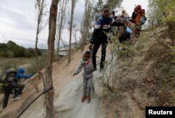 FILE - Migrants from Somalia try to reach Greece's border with Macedonia, near the Greek village of Idomeni, Sept. 8, 2015.