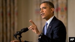 FILE - President Barack Obama gestures while making the second of three points while speaking in the State Dining Room of the White House.