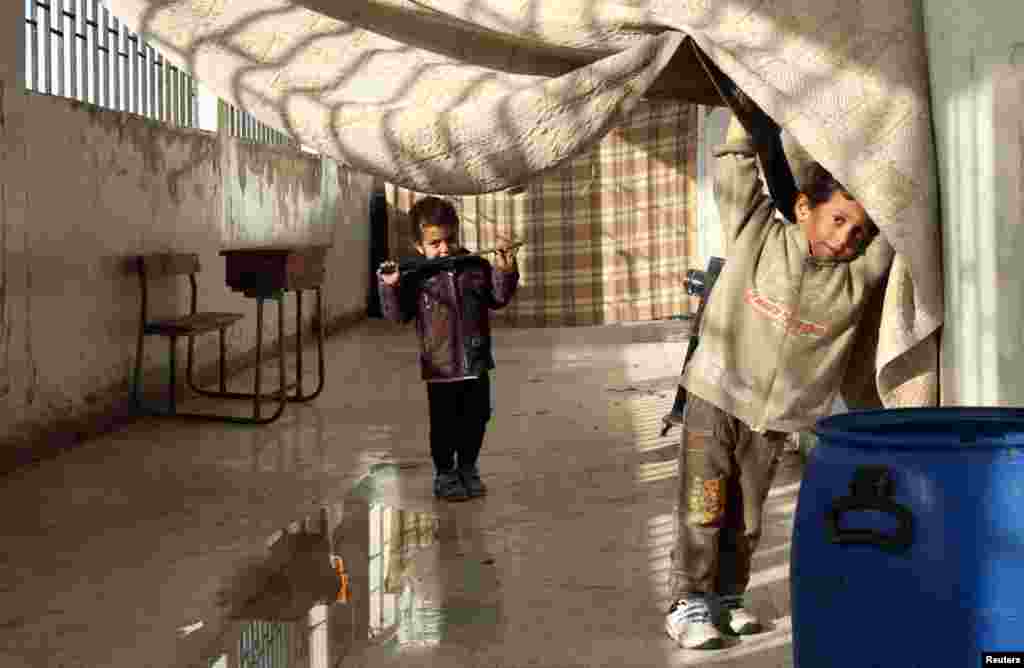 An internally displaced boy looks out of a school at a village outside Damascus, January 28, 2013.
