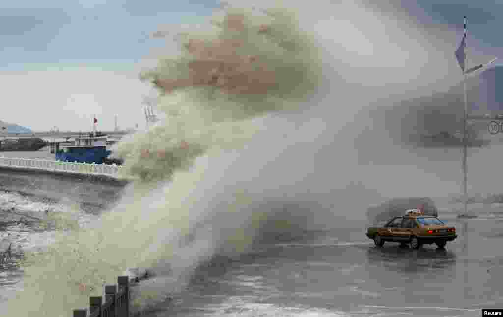 A storm surge under the influence of Typhoon Usagi overtakes vehicles at the coastline in Lianyungang, Jiangsu province, Sept. 24, 2013.&nbsp;