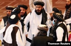 FILE - Taliban delegates speak during talks between the Afghan government and Taliban insurgents in Doha, Qatar, Sept. 12, 2020.