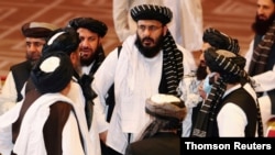 FILE - Taliban delegates speak during talks between the Afghan government and Taliban insurgents in Doha, Qatar, Sept. 12, 2020.