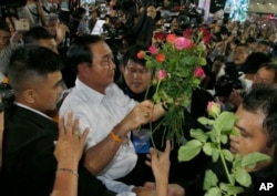 Prayut Chan-ocha of the Palang Pracharat Party receives flowers from supporters during an election campaign rally in Bangkok, Thailand, March 22, 2019.