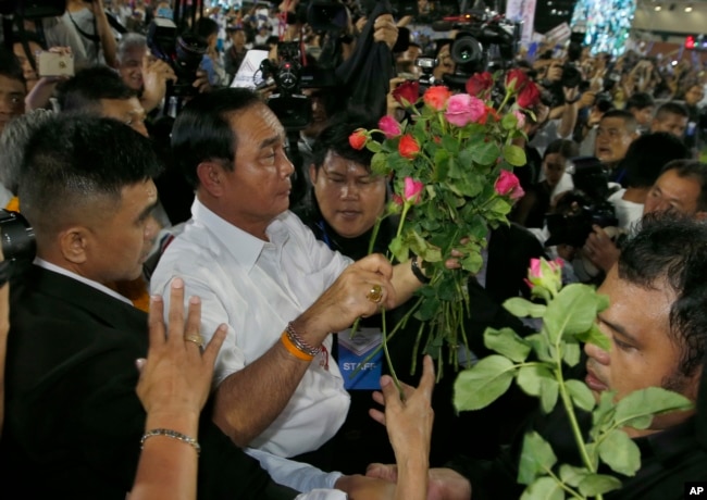 Prayut Chan-ocha of the Palang Pracharat Party receives flowers from supporters during an election campaign rally in Bangkok, Thailand, March 22, 2019.