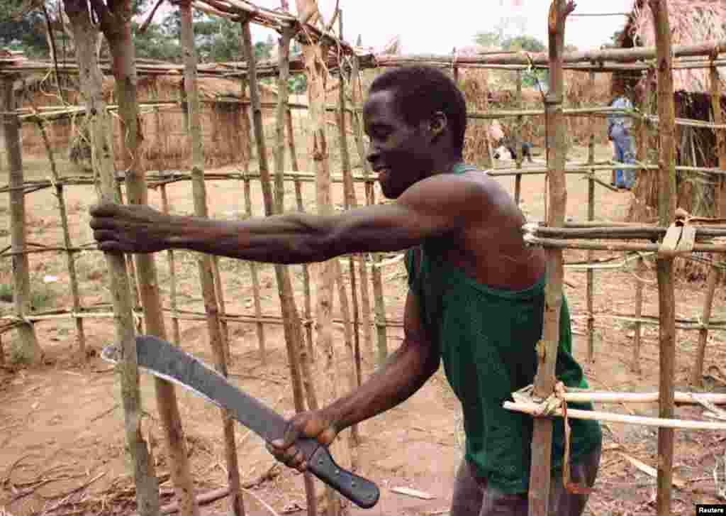 Refugiado angolano constroi um abrigo no acampamento de Caxito, onde 14 mil pessoas se refugiam da sangrenta guerra civil em Angola. Foto de 1998.&nbsp;