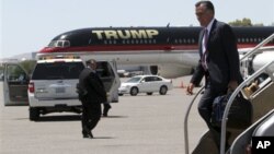 Republican presidential candidate, former Massachusetts Governor Mitt Romney walks past Donald Trump's airplane as he arrives in Las Vegas, May 29, 2012.