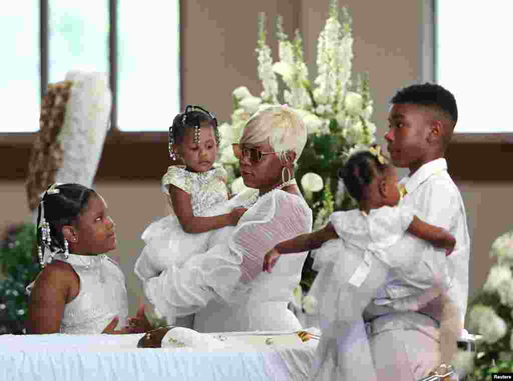 Tomika Miller, the widow of Rayshard Brooks, who was shot dead June 12 by an Atlanta police officer, holds their 2-year-old daughter Memory with her other children during his funeral at Ebenezer Baptist Church in Atlanta, Georgia.