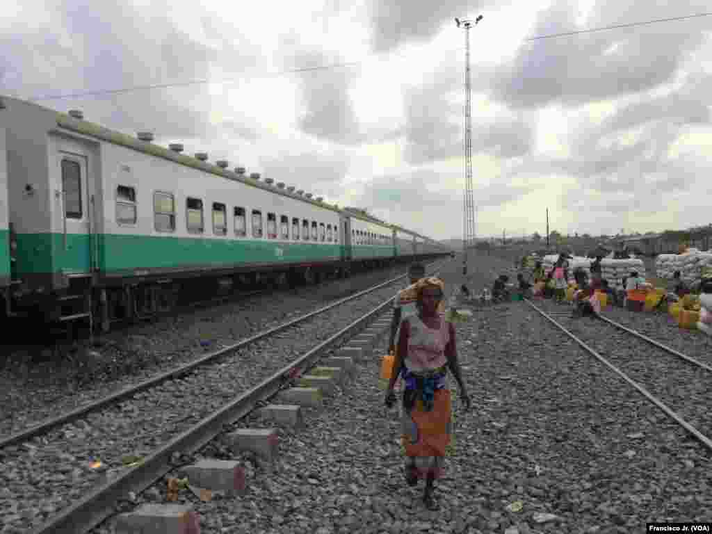 Uma mulher caminha ao lado da linha férra na estação dos Caminhos de Ferro de Moçambique em Moatize