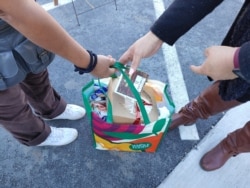 Low income families receive bags filled with traditional Thanksgiving food like stuffing and pumpkin pie at Mount Vernon Woods Elementary School in Alexandria, Virginia. (Deborah Block/VOA)