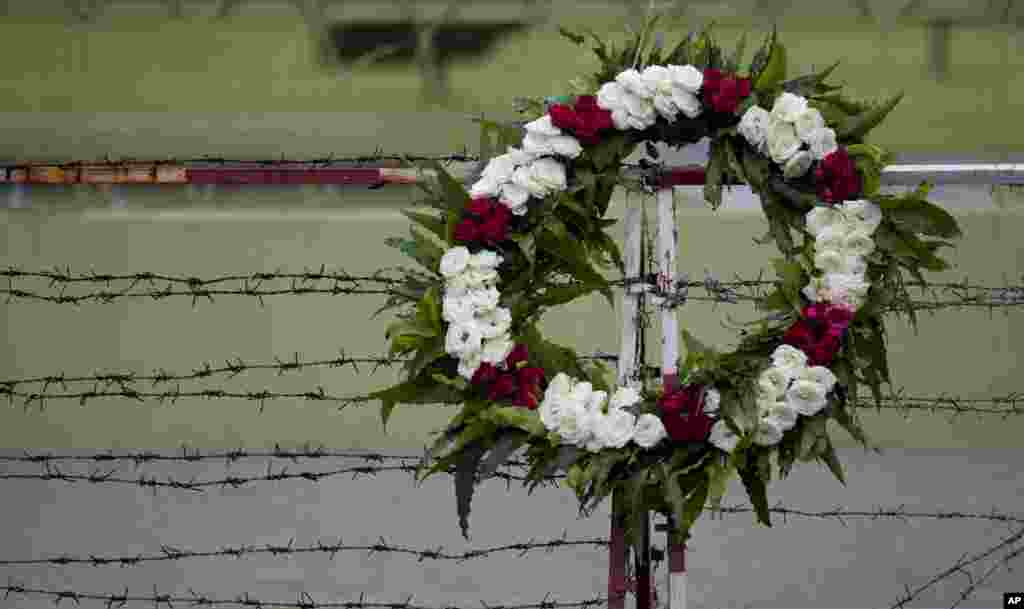A wreath is kept on a barbed-wired roadside barrier outside Yangon city hall commemorating the victims of August 8, 1988 pro-democracy uprising in Rangoon, August 8, 2013.