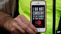 FILE - A man holds up his iPhone during a rally in support of data privacy outside the Apple Store in San Francisco, Feb. 23, 2016.