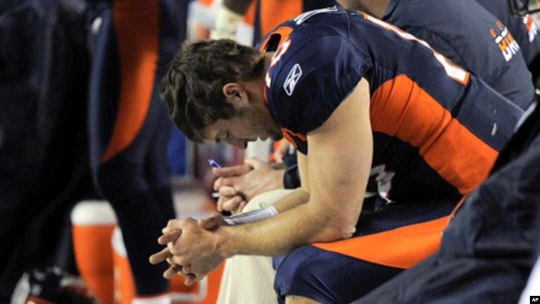 Pemain belakang tim sepakbola Denver Broncos, Tim TEbow, berdoa saat duduk di bangku cadangan dalam pertandingan melawan Kansas City Chiefs. (Foto: Dok)