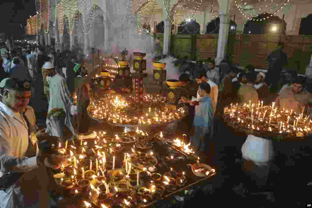 People light oil lamps during the three-day annual festival of saint Al-Sheikh Ali Bin Usman Al-Hajveri known as Data Ganjbaksh, at his shrine, in Lahore, Pakistan.