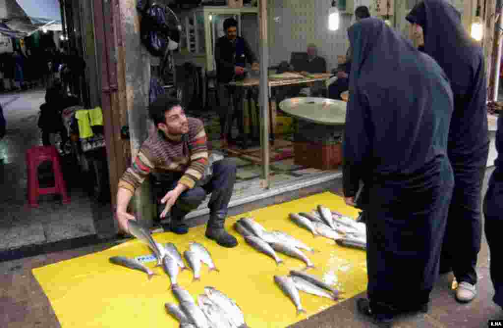 بازار ماهی فروشهای رشت. فروشنده و خریدار بر سر قیمت بحث می کنند. عکس: ابوذر حمیدی