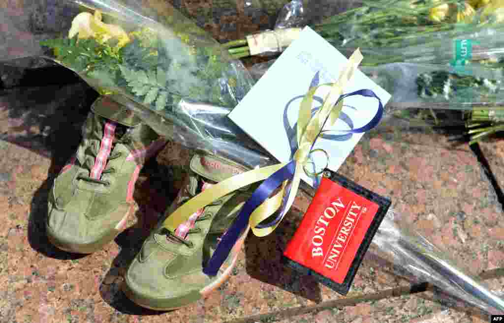 Boston University School of Theology graduate student, Meghan Nelson(not seen) placed a pair of running shoes, flowers and a Boston University key chain at a makeshift memorial for fellow student 23-year-old Lu Lingzi from China, April 17, 2013